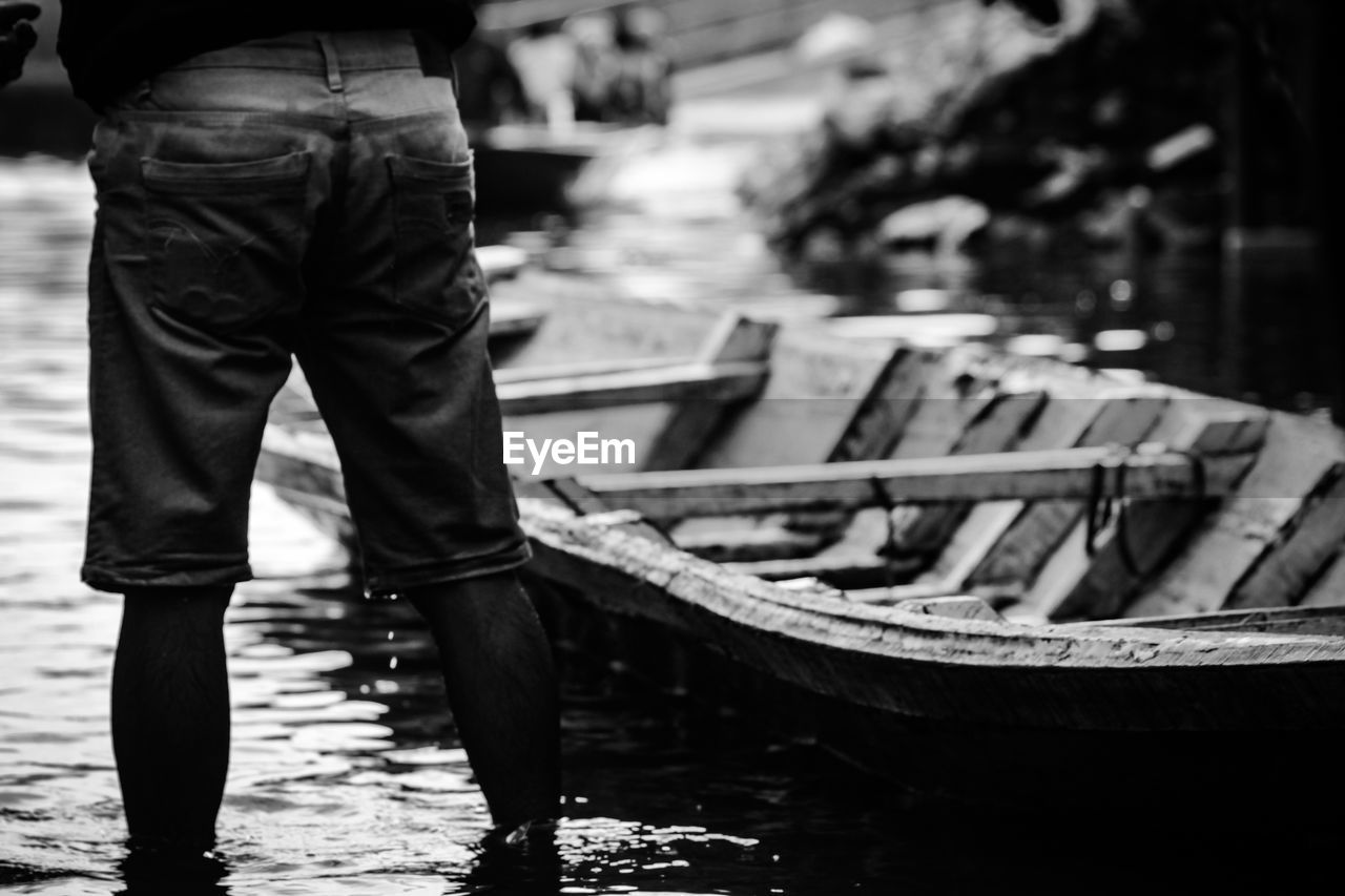 Low section of man standing on boat