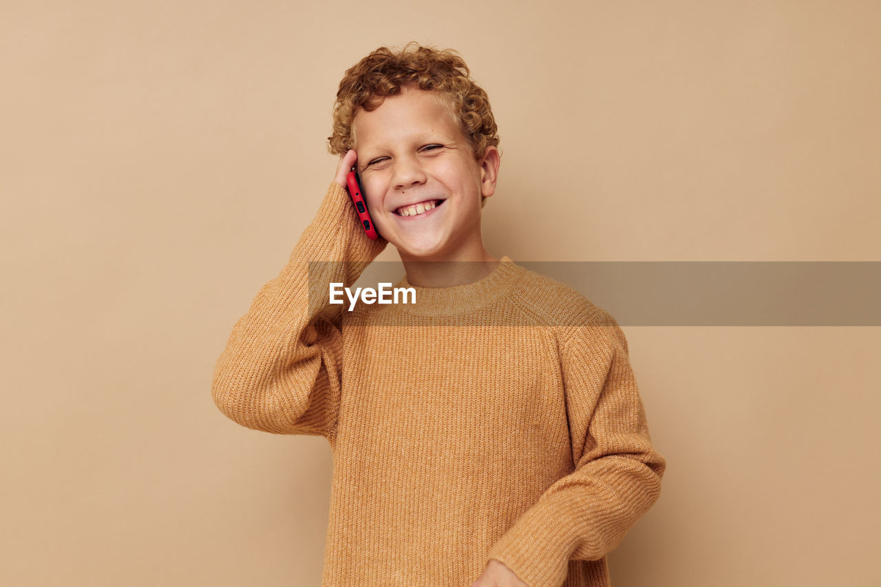 Portrait of smiling boy talking on phone