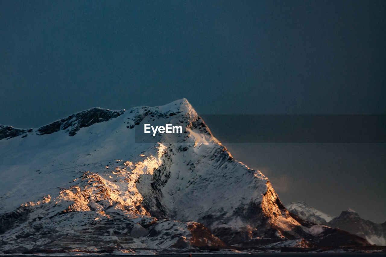 Scenic view of snowcapped mountain against sky at dusk