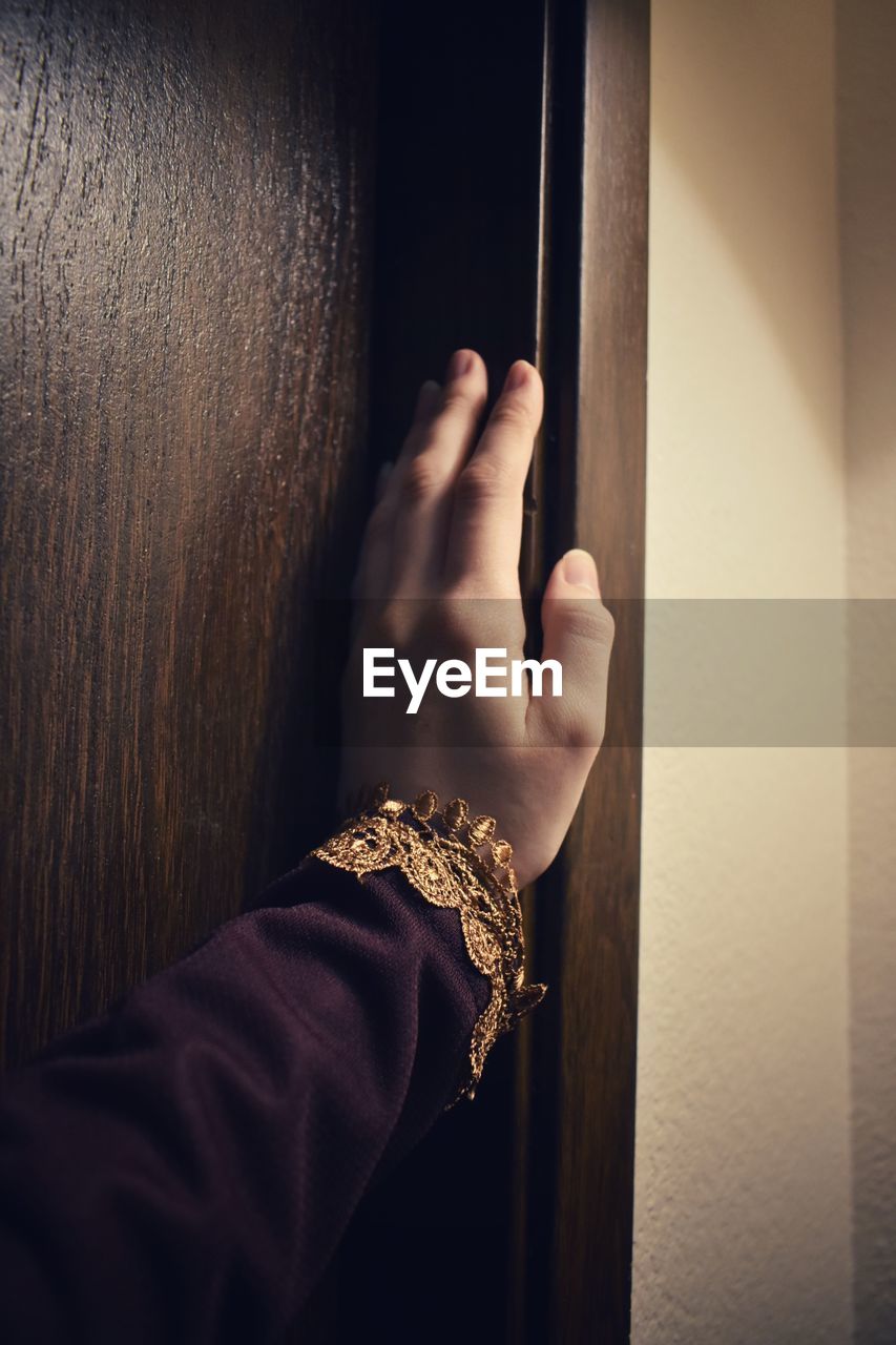 CLOSE-UP OF PERSON HAND HOLDING METAL DOOR