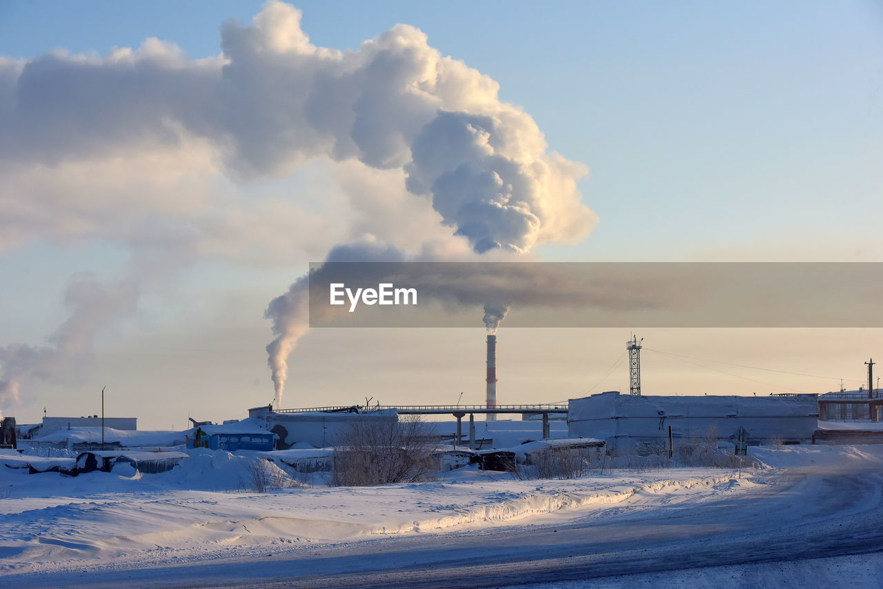 SMOKE EMITTING FROM FACTORY AGAINST CLOUDY SKY