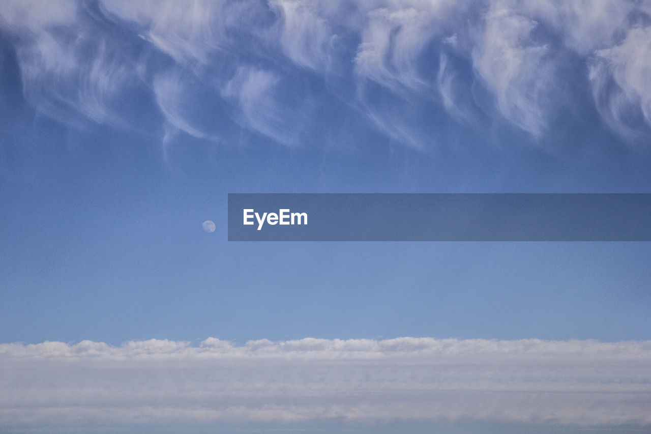 LOW ANGLE VIEW OF BLUE SKY AND MOON IN CLOUDY DAY