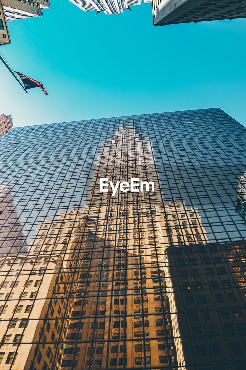 Low angle view of skyscrapers against blue sky