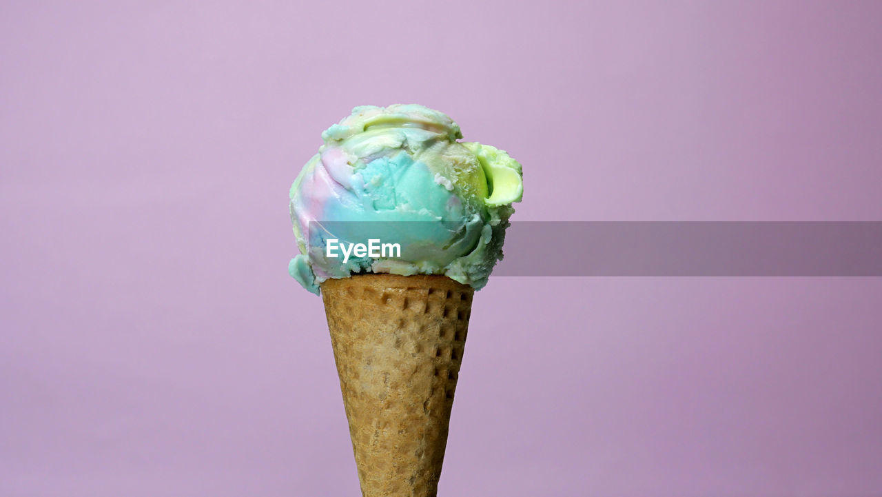 CLOSE-UP OF ICE CREAM AGAINST COLORED BACKGROUND