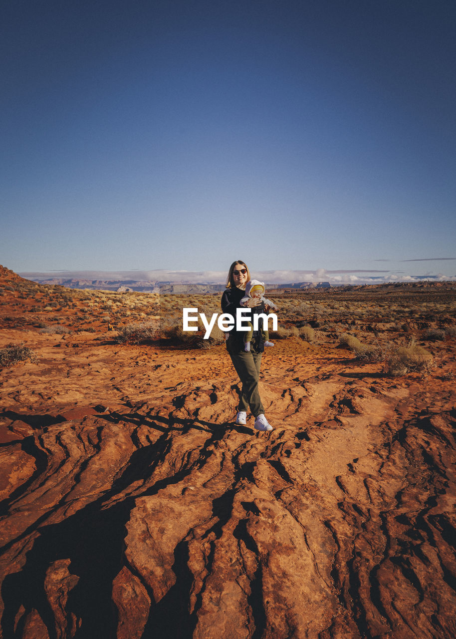 A woman with a child is standing near horseshoe bend, arizona