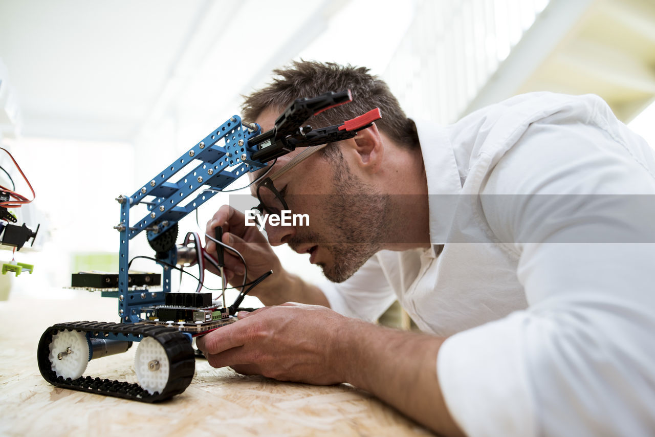 Engineer examining drone at table in office