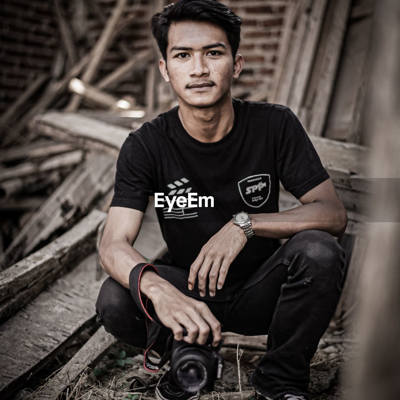 PORTRAIT OF YOUNG MAN SITTING ON FLOOR