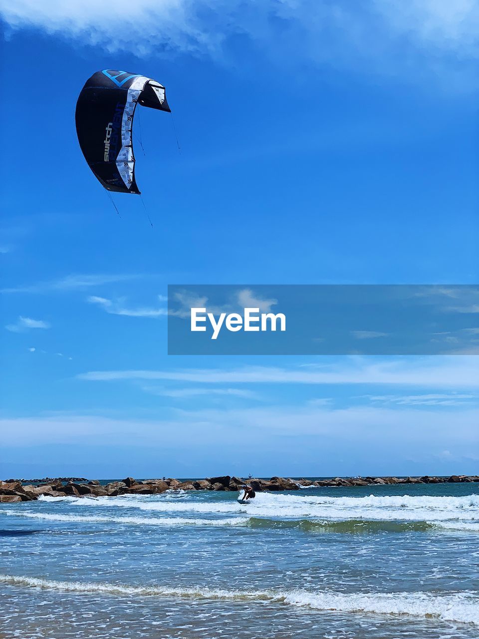 PERSON PARAGLIDING OVER SEA