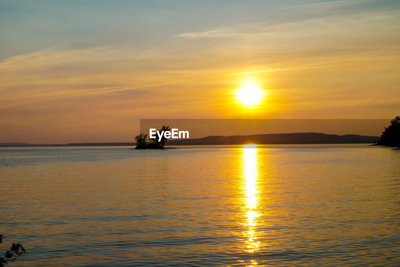 Scenic view of lake against romantic sky at sunset