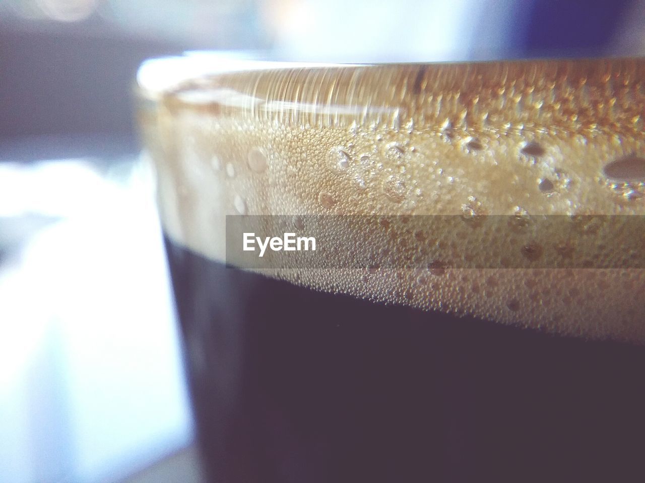 CLOSE-UP OF BEER GLASS ON TABLE