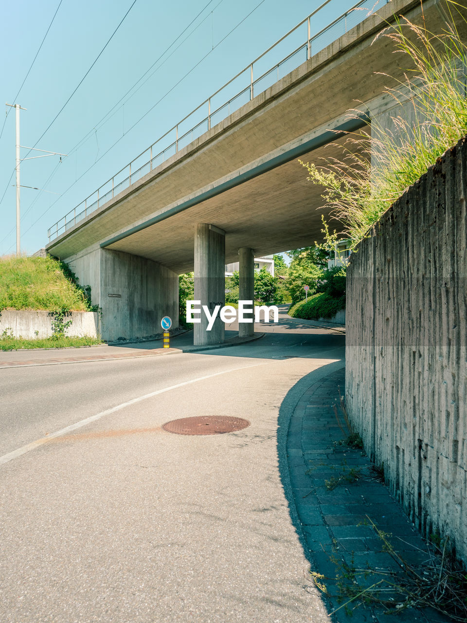 EMPTY ROAD BY BUILDINGS AGAINST SKY