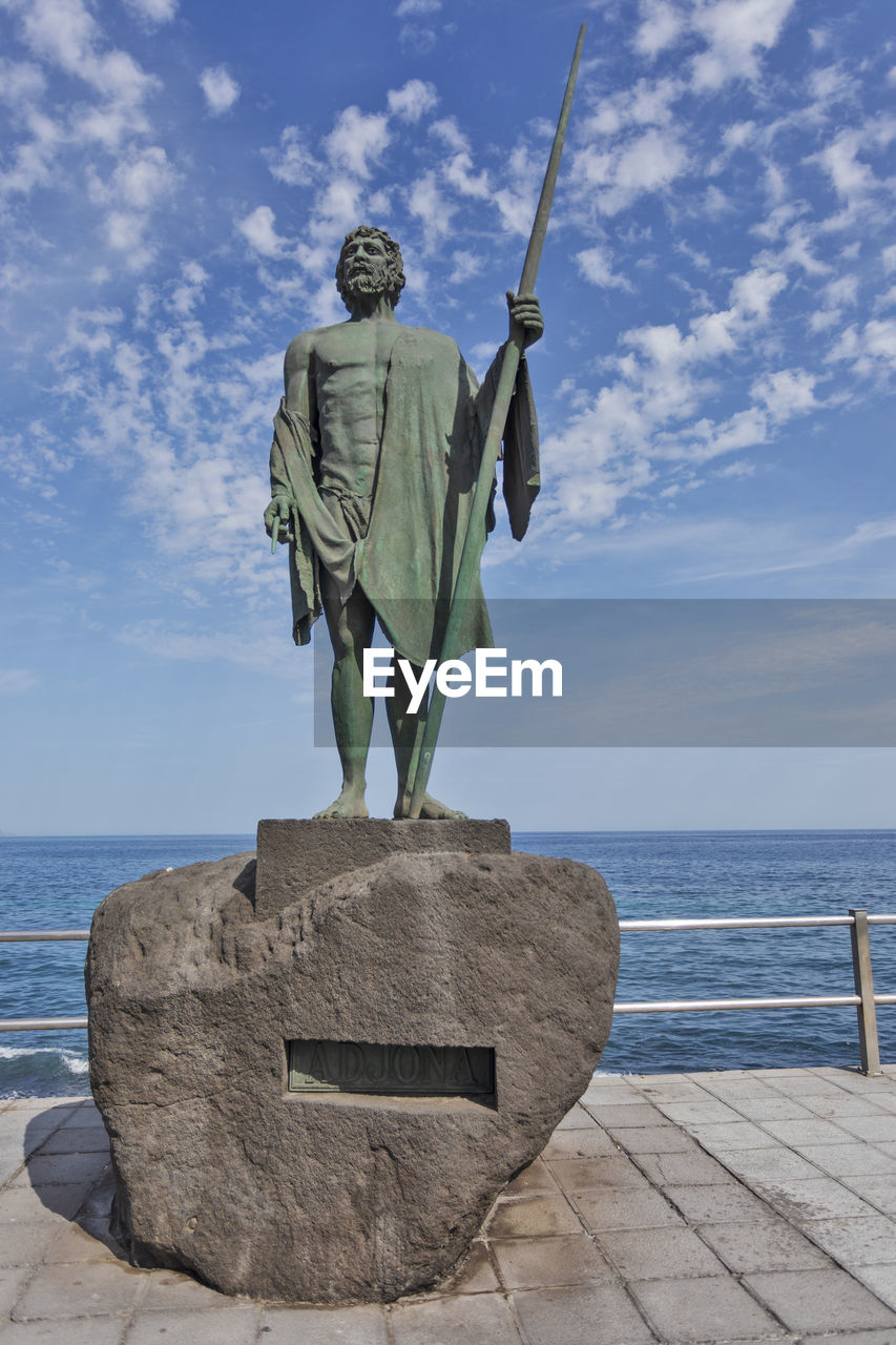 sky, water, sculpture, sea, statue, nature, human representation, blue, representation, horizon over water, craft, monument, vacation, day, cloud, memorial, art, horizon, travel destinations, male likeness, no people, outdoors, travel, beach, architecture, history, the past, creativity