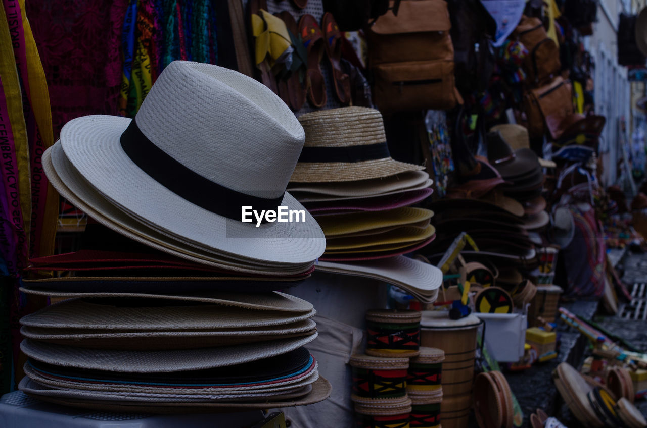 hat, clothing, fashion accessory, sombrero, large group of objects, market, retail, sun hat, no people, fedora, abundance, for sale, business, market stall, variation