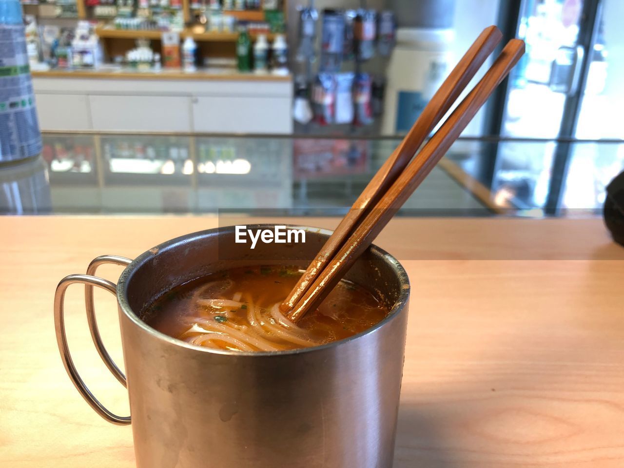 CLOSE-UP OF COFFEE IN GLASS ON TABLE