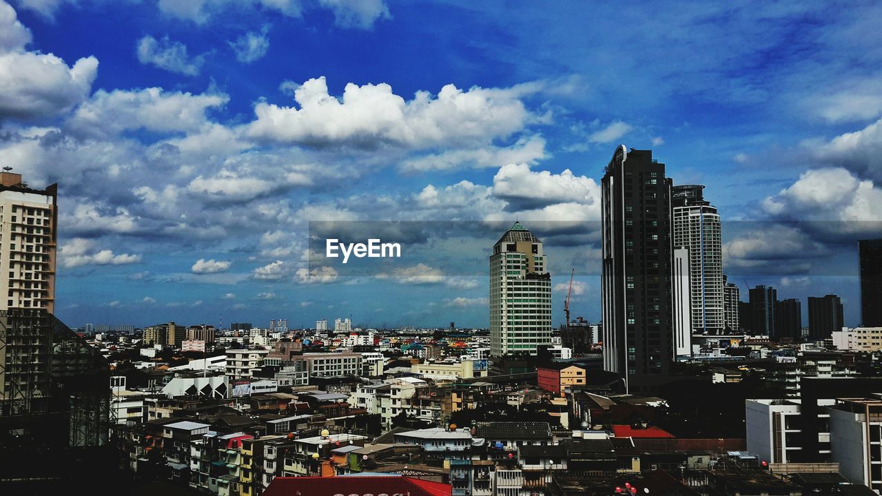 SKYSCRAPERS AGAINST CLOUDY SKY