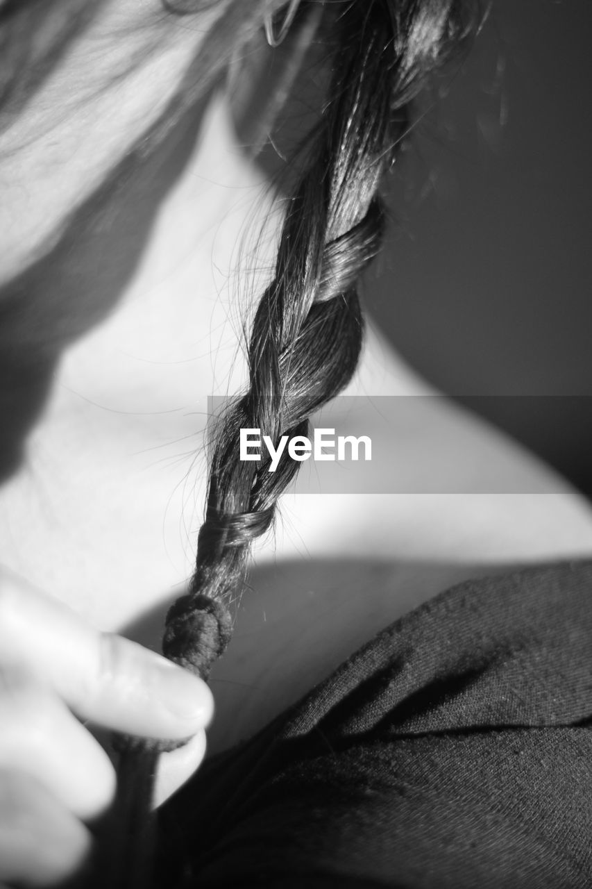 Cropped image of woman holding braided hair