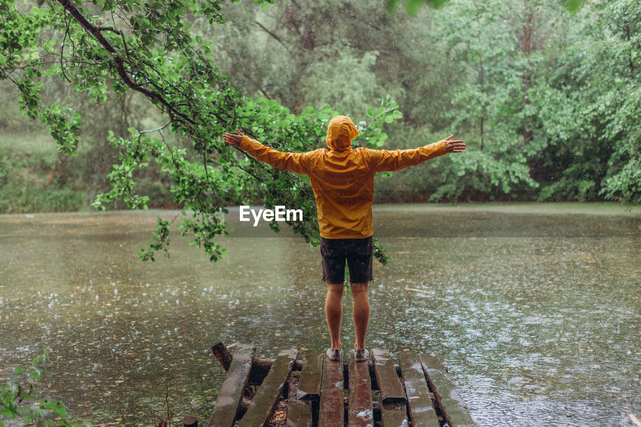 Full length rear view of man standing in rain