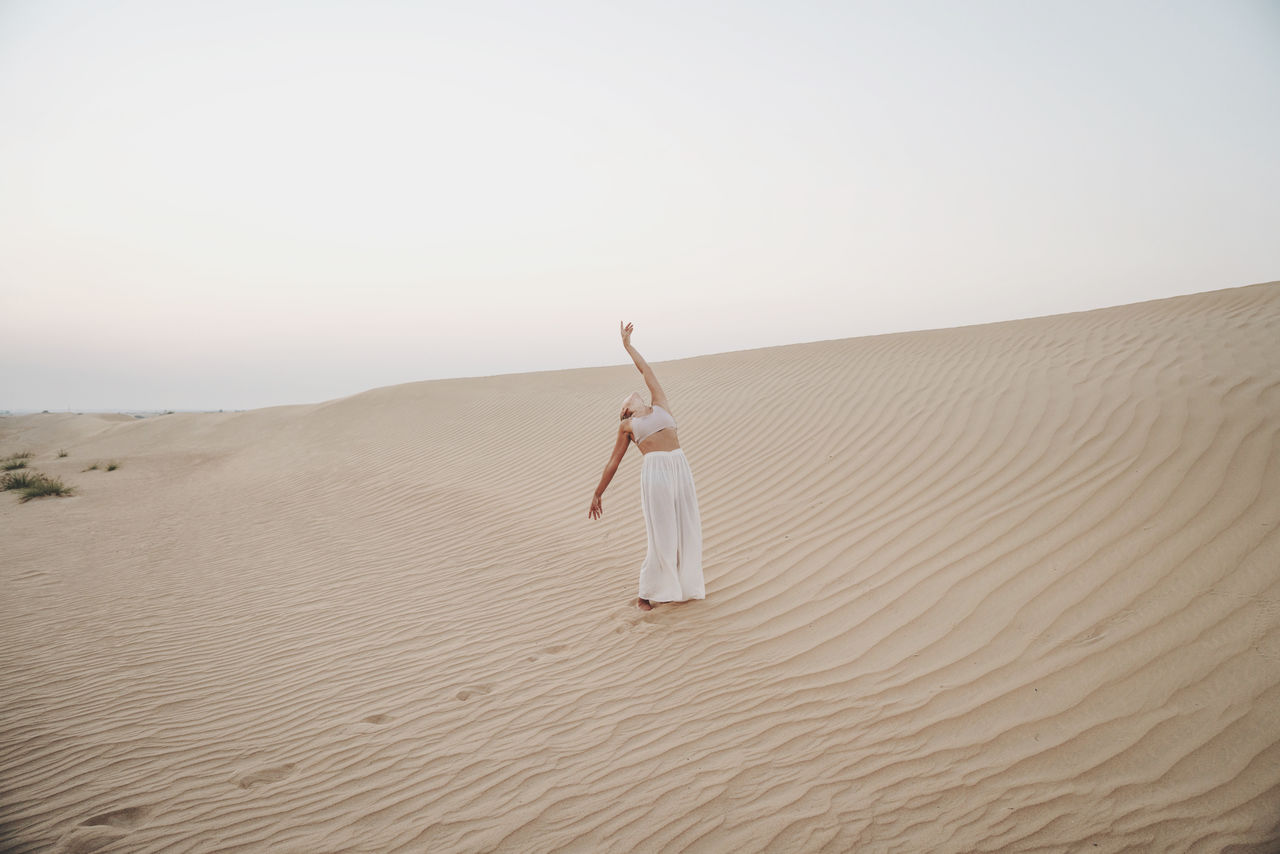 Woman in the desert with arms raised