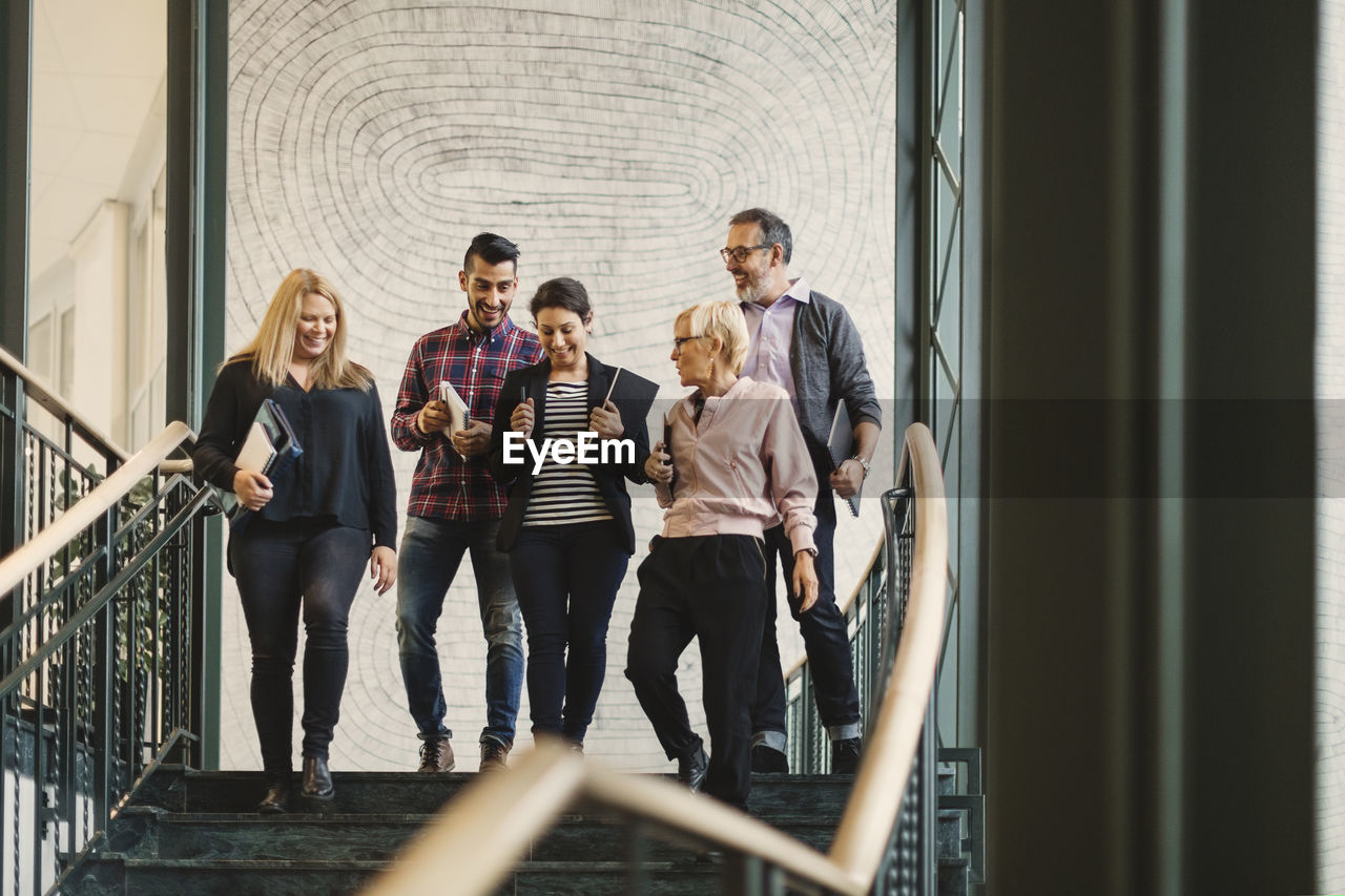 Team of creative business people moving downstairs at office