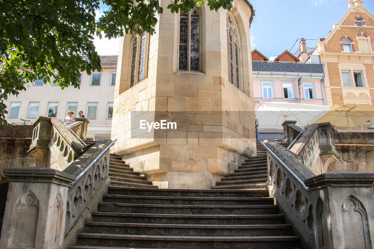 LOW ANGLE VIEW OF STAIRCASE AMIDST BUILDINGS