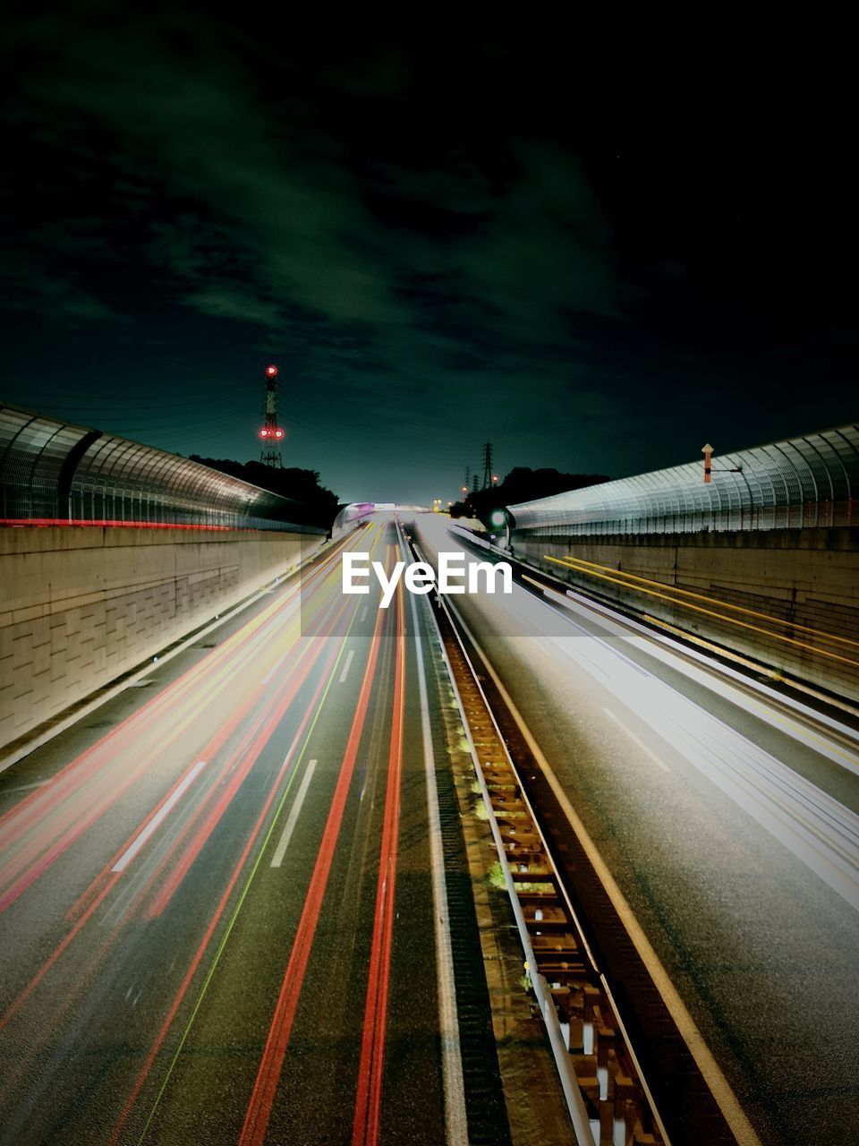 BLURRED MOTION OF LIGHT TRAILS ON ROAD IN CITY AT NIGHT