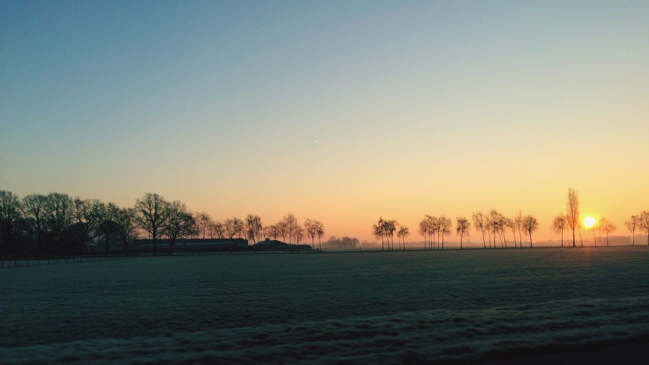 Scenic view of landscape against clear sky at sunset