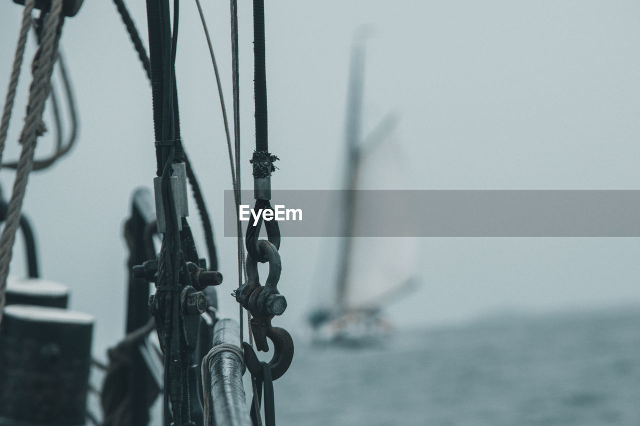 Close-up of sailboat on sea against sky with blurred sailboat behind 