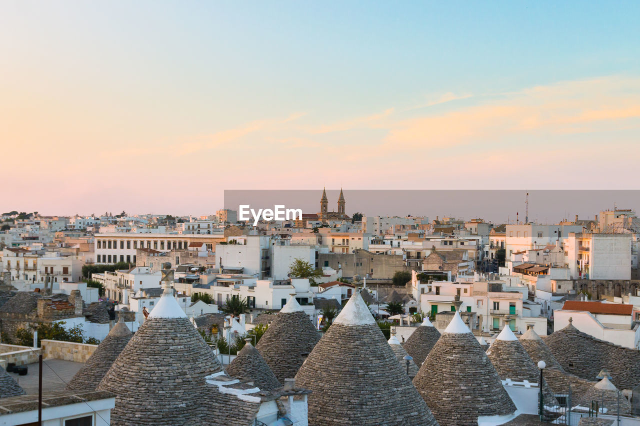 Aerial view of buildings in city against sky during sunset