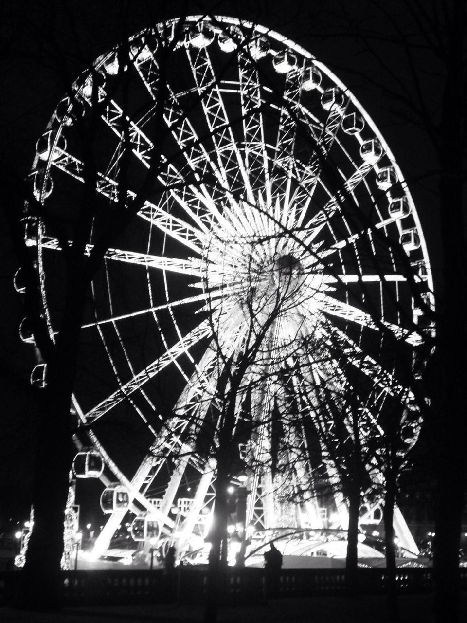 LOW ANGLE VIEW OF ILLUMINATED FERRIS WHEEL AT NIGHT