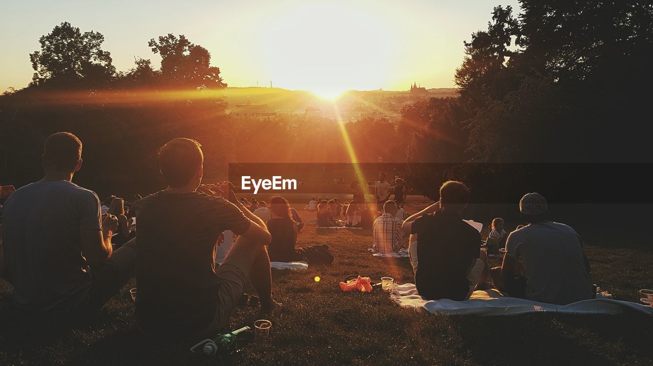 People enjoying on field in park during sunset