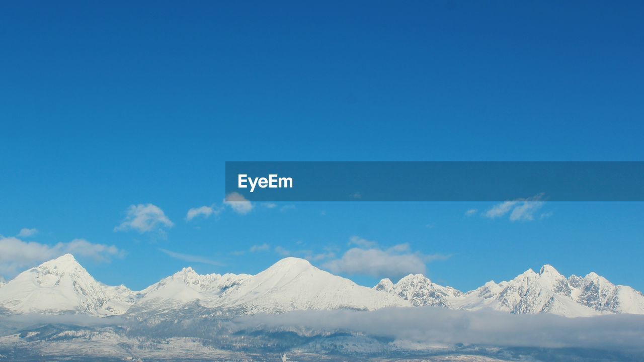 SCENIC VIEW OF SNOWCAPPED MOUNTAIN AGAINST BLUE SKY