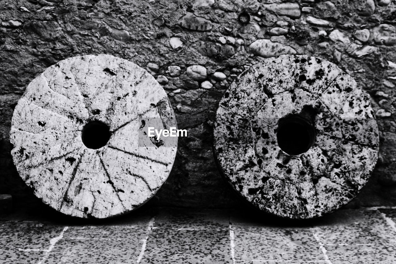 Old stone wheels against wall