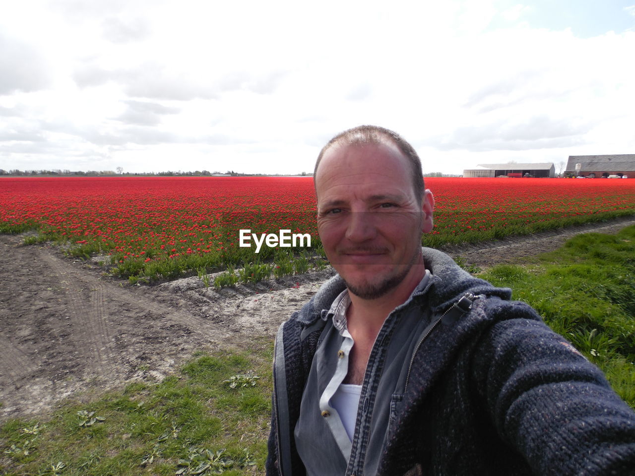 PORTRAIT OF SMILING MAN IN FIELD