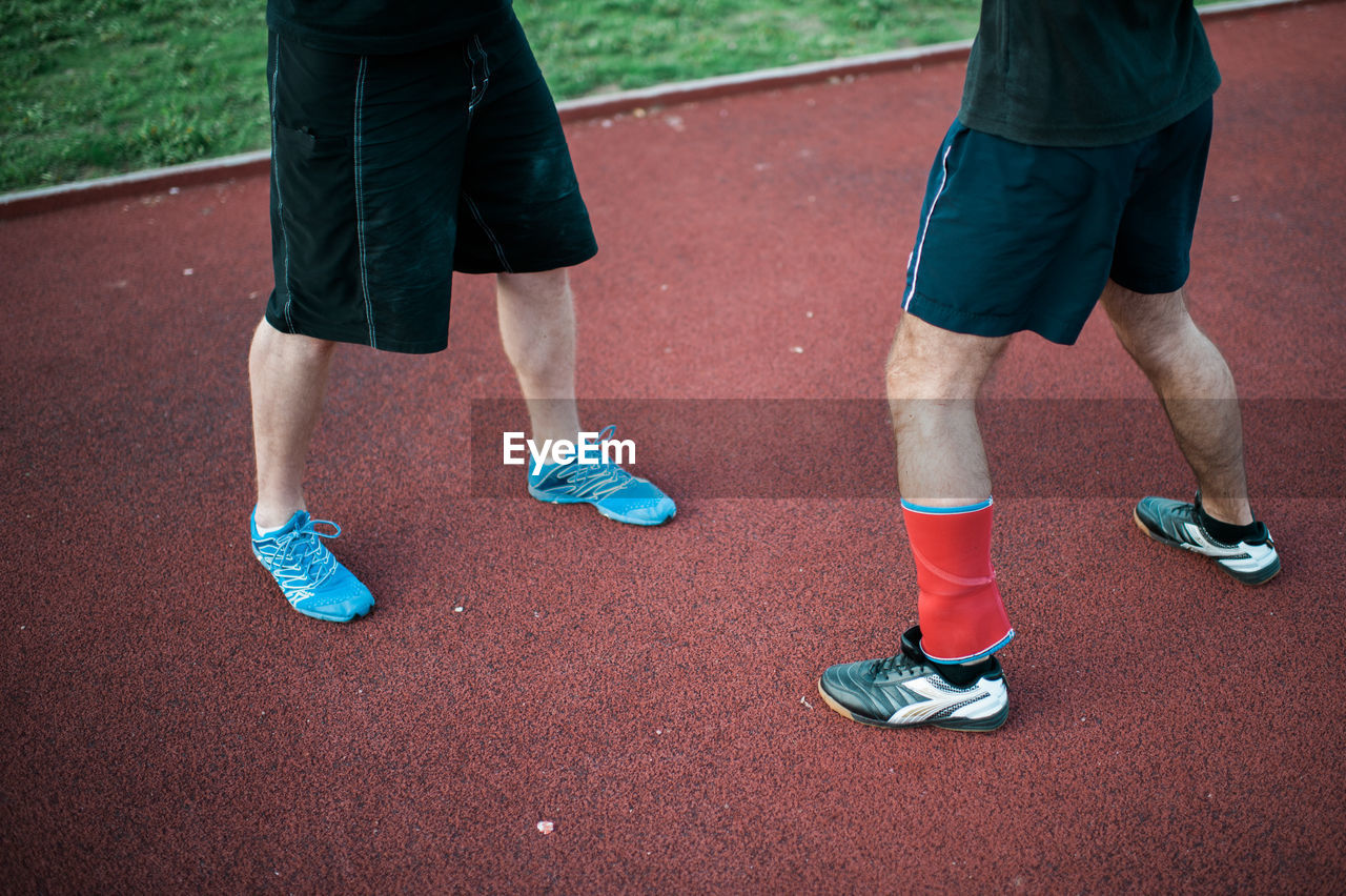 Low section of man standing on field