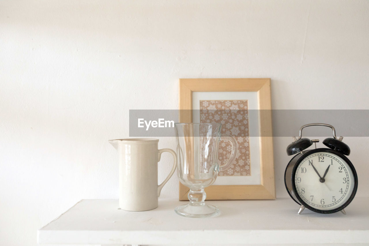 Black alarm clock vase and glass on table