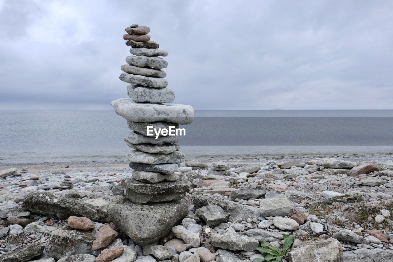 rock, sea, sky, water, balance, cloud, stone, land, beach, nature, shore, pebble, tranquility, zen-like, coast, beauty in nature, horizon, scenics - nature, horizon over water, tranquil scene, no people, ocean, sand, day, outdoors, environment, idyllic, non-urban scene, stability, coastline, breakwater, landscape, body of water