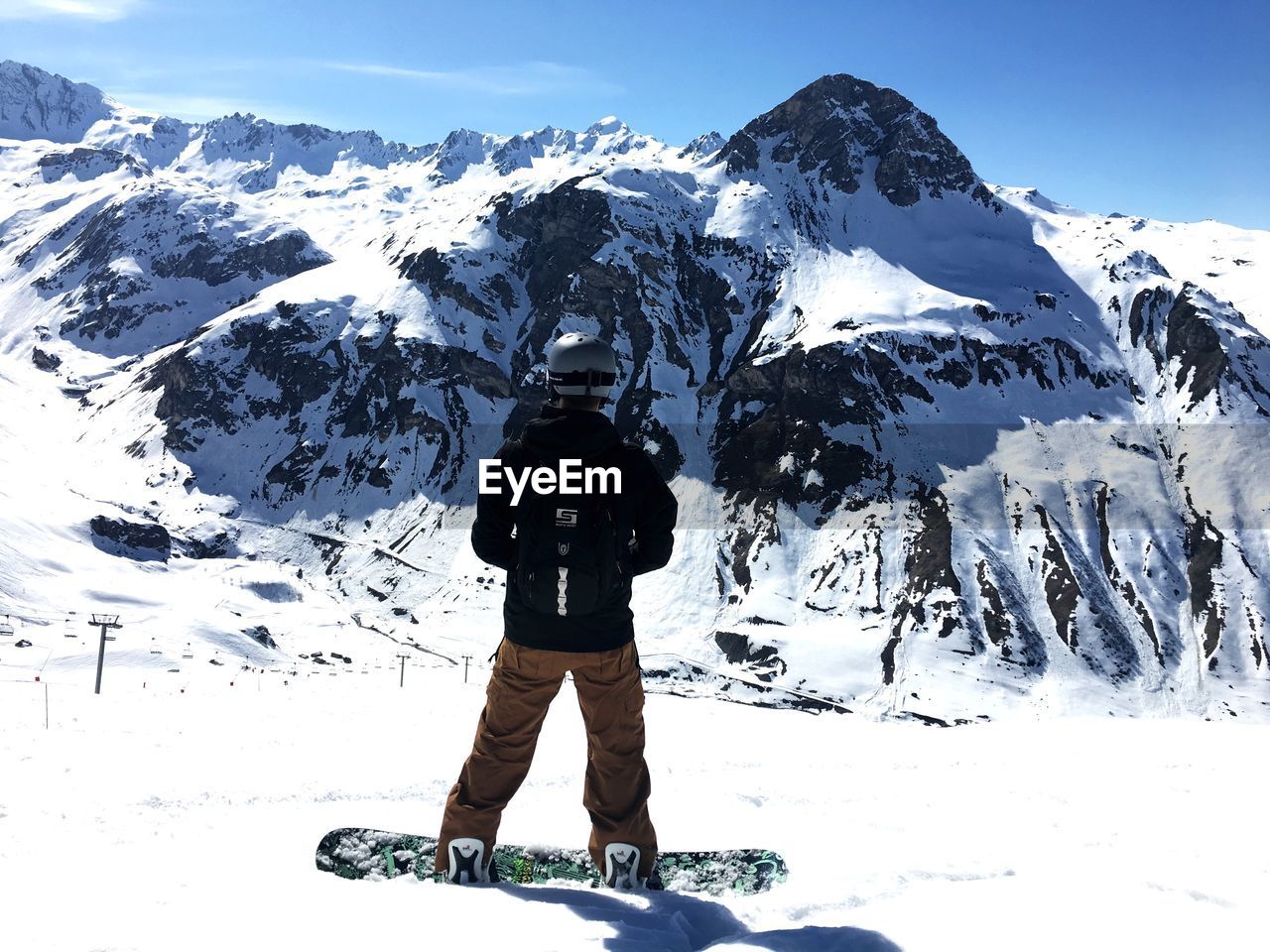 REAR VIEW OF WOMAN WALKING ON SNOWCAPPED MOUNTAIN