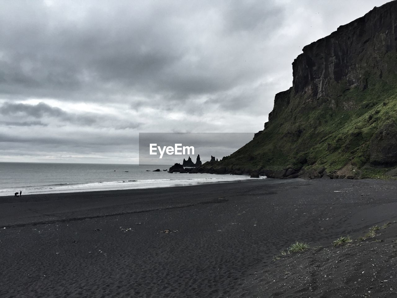 Scenic view of mountain and sea against cloudy sky