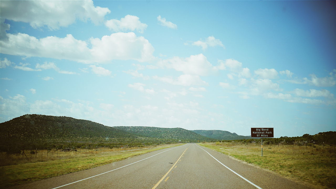 EMPTY ROAD WITH TREES IN BACKGROUND