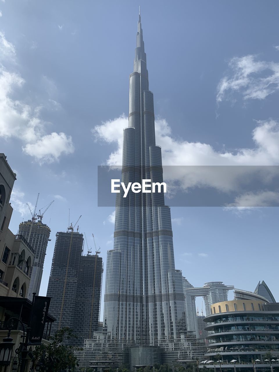 LOW ANGLE VIEW OF BUILDINGS IN CITY AGAINST CLOUDY SKY