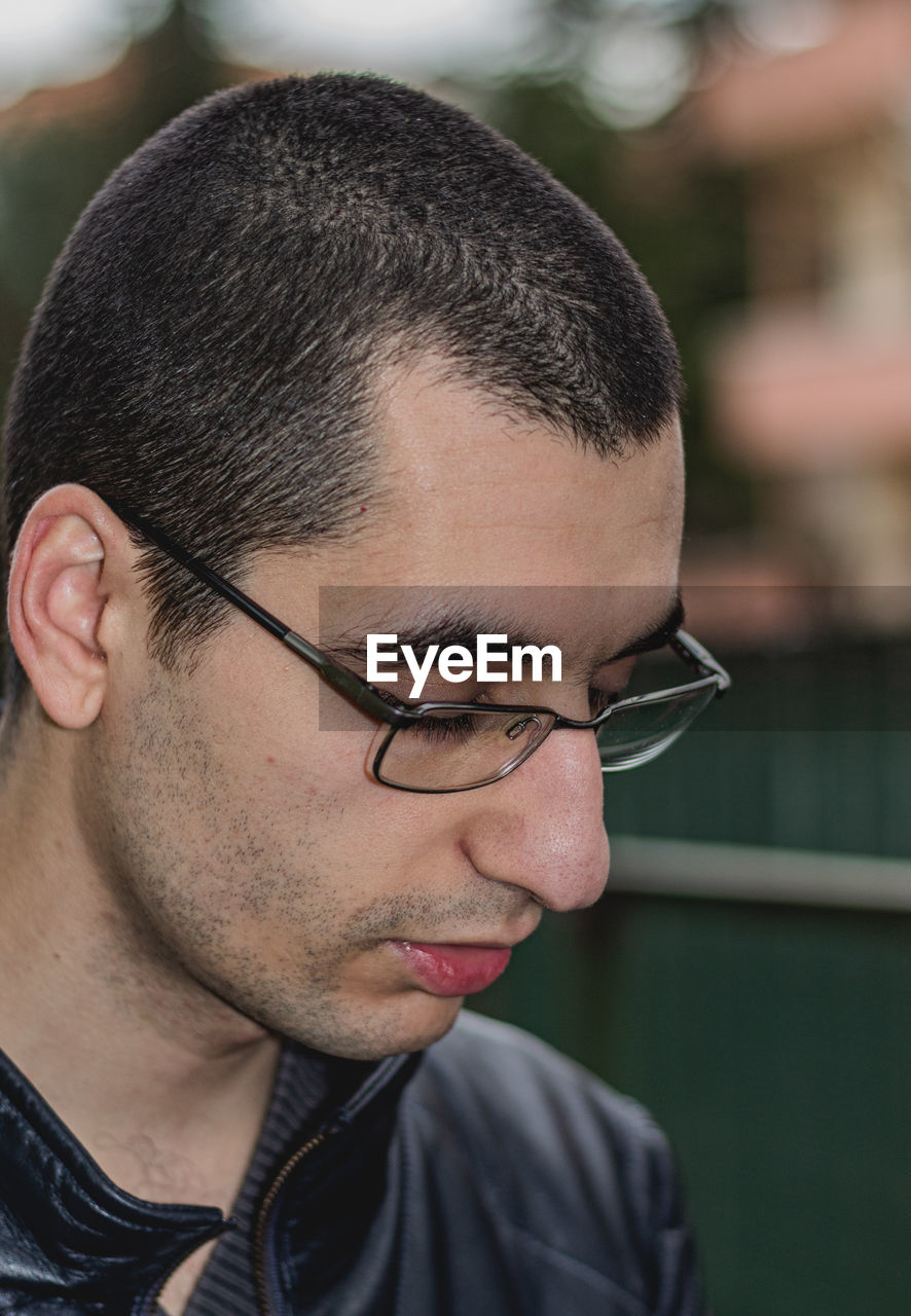 CLOSE-UP PORTRAIT OF YOUNG MAN WITH EYEGLASSES