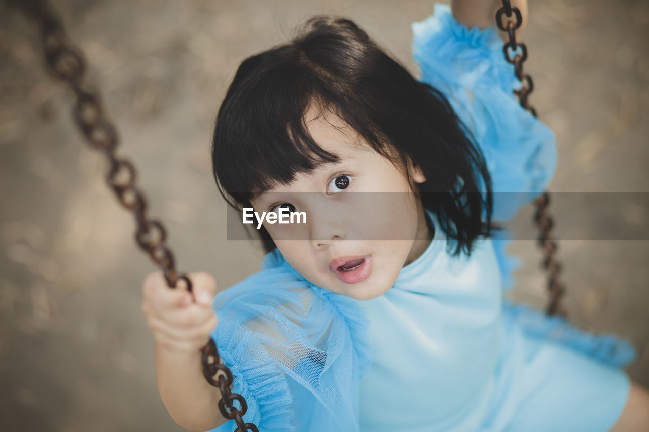 PORTRAIT OF CUTE GIRL HOLDING CAMERA OUTDOORS