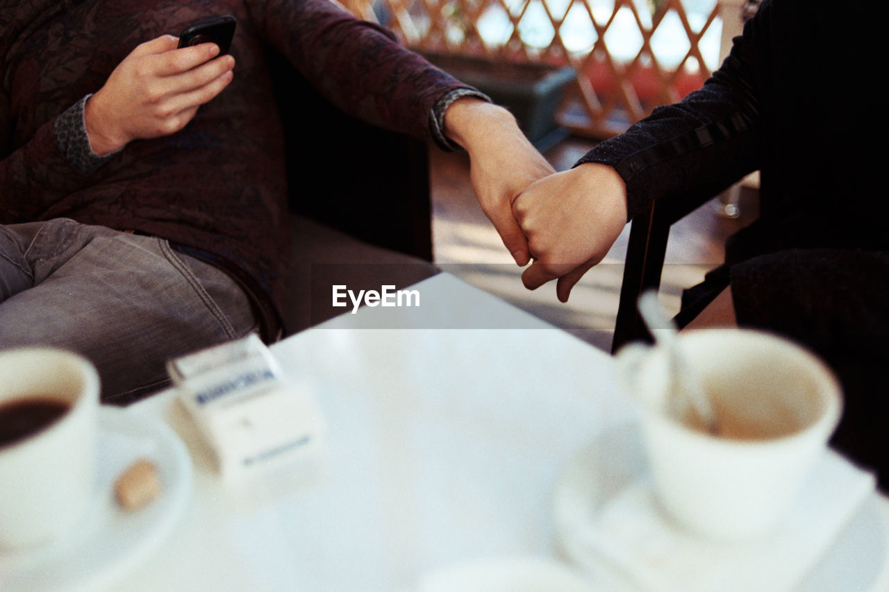 Midsection of couple sitting at table