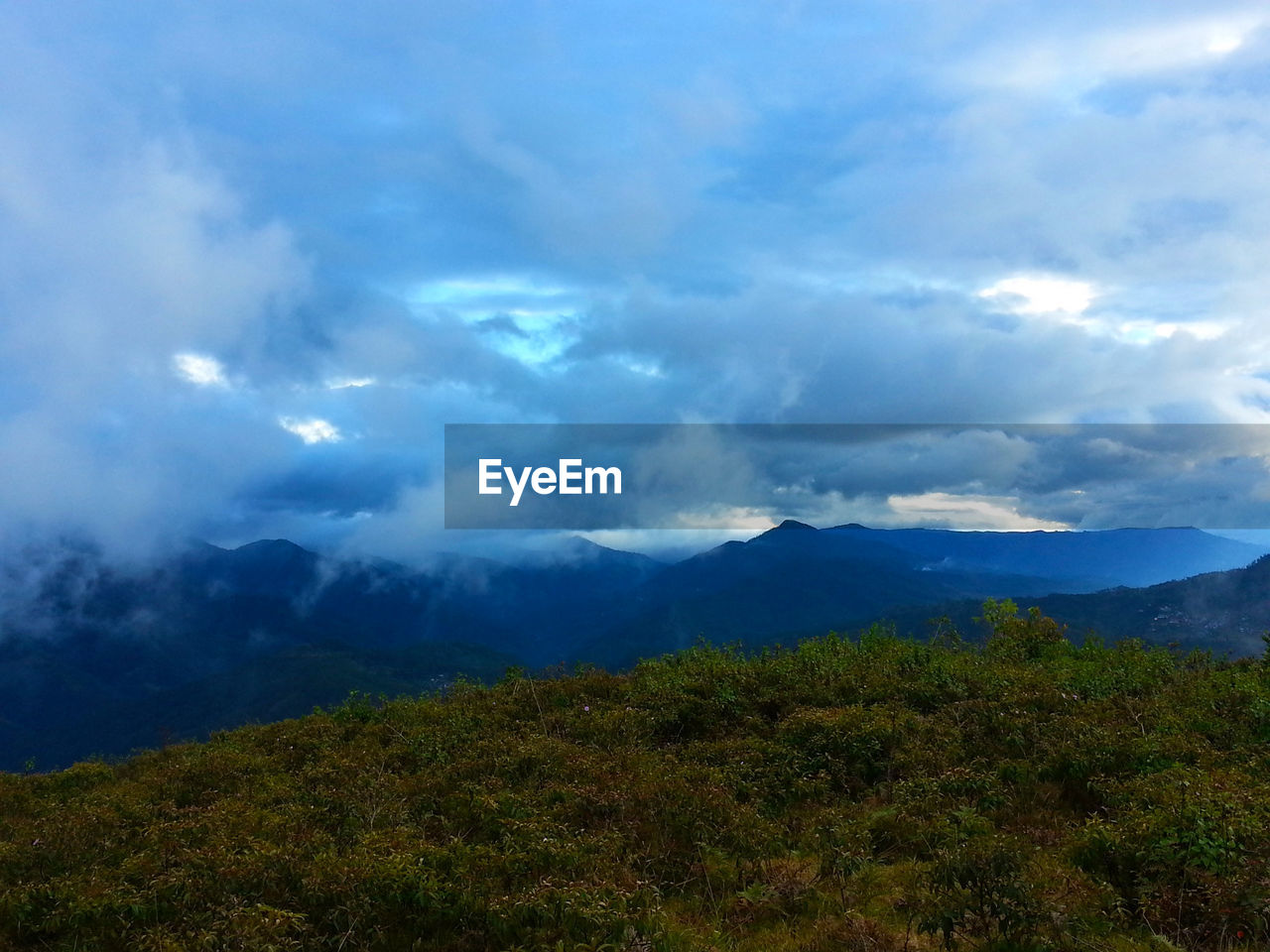 SCENIC VIEW OF MOUNTAINS AGAINST CLOUDY SKY