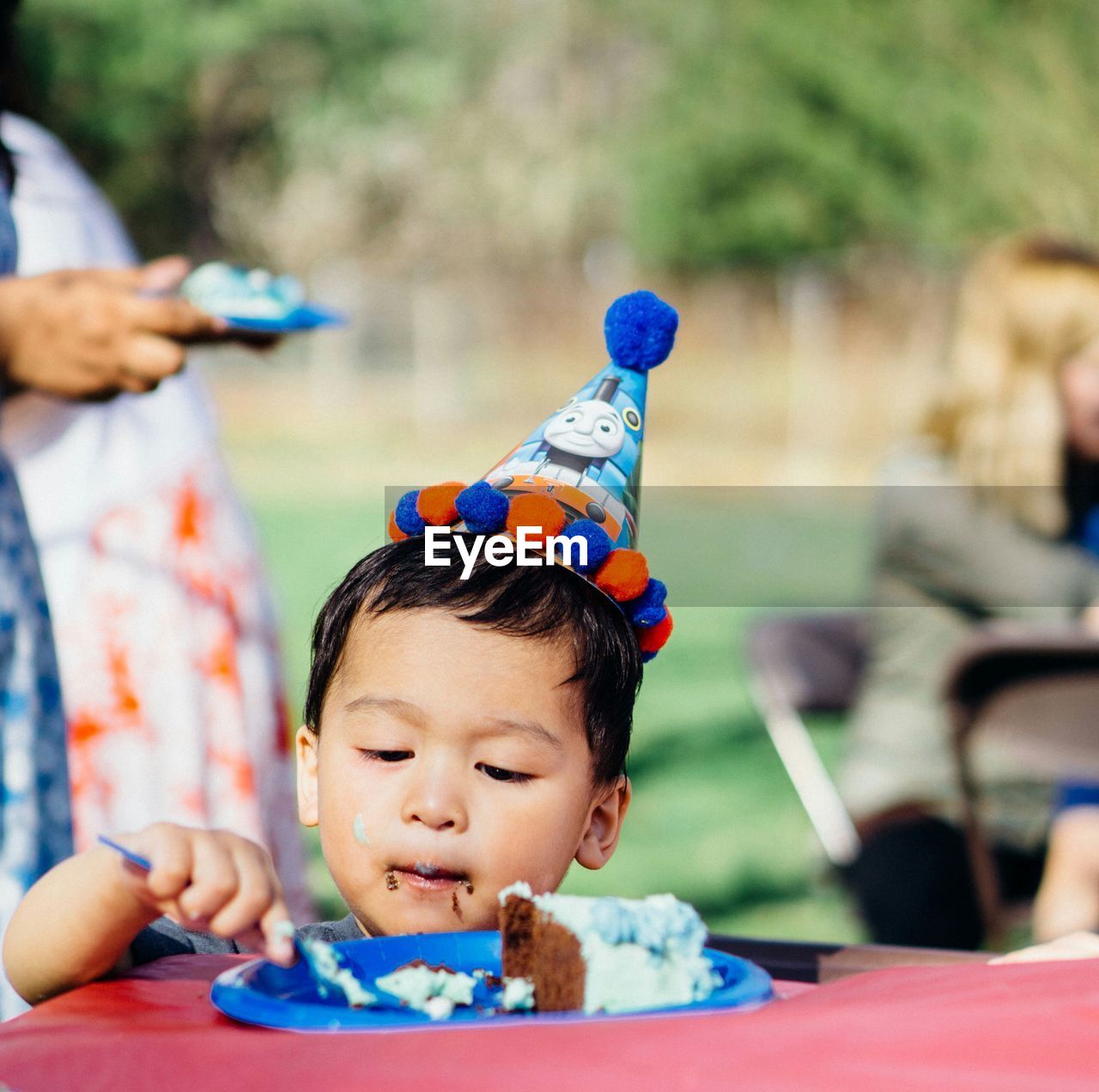 Boy in party hat eating cake