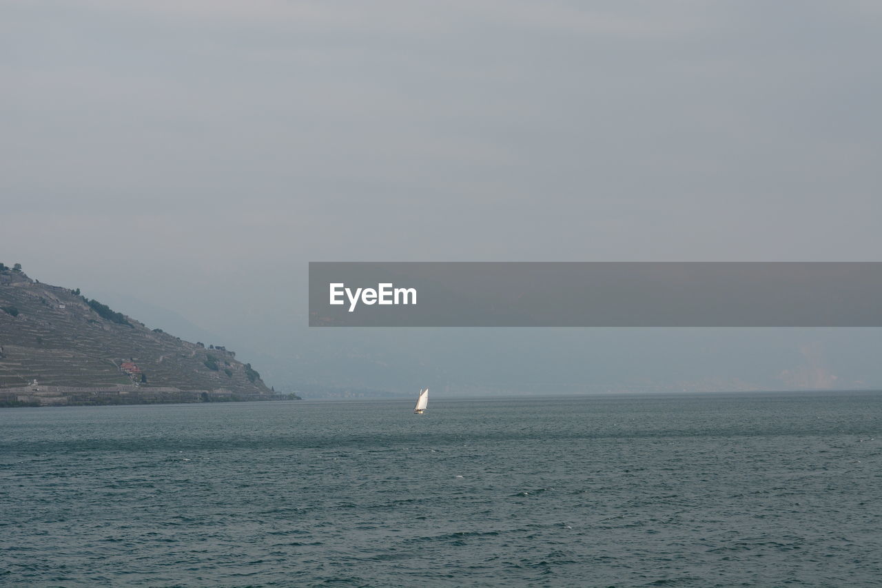 SAILBOATS IN SEA AGAINST SKY