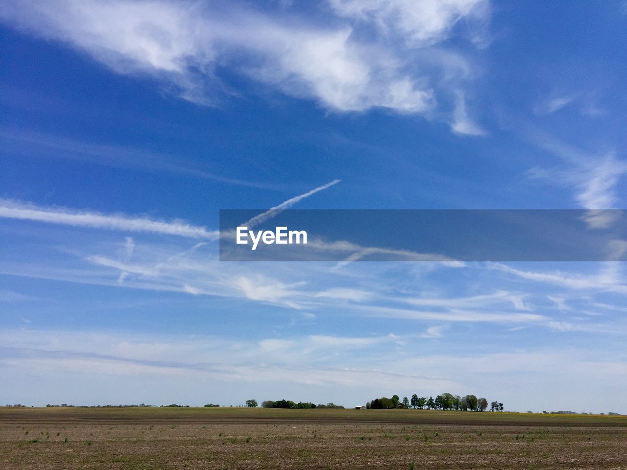 Scenic view of field against cloudy sky