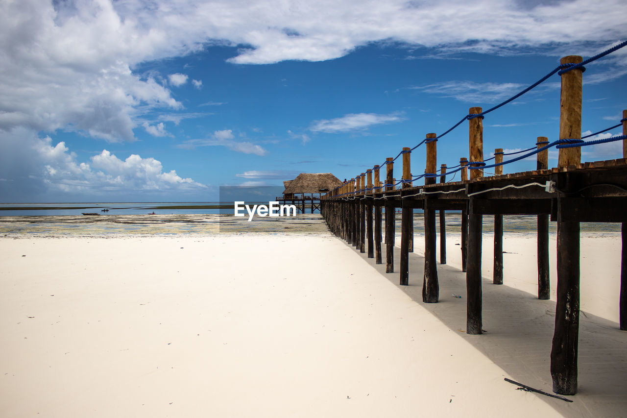 Pier on beach against sky