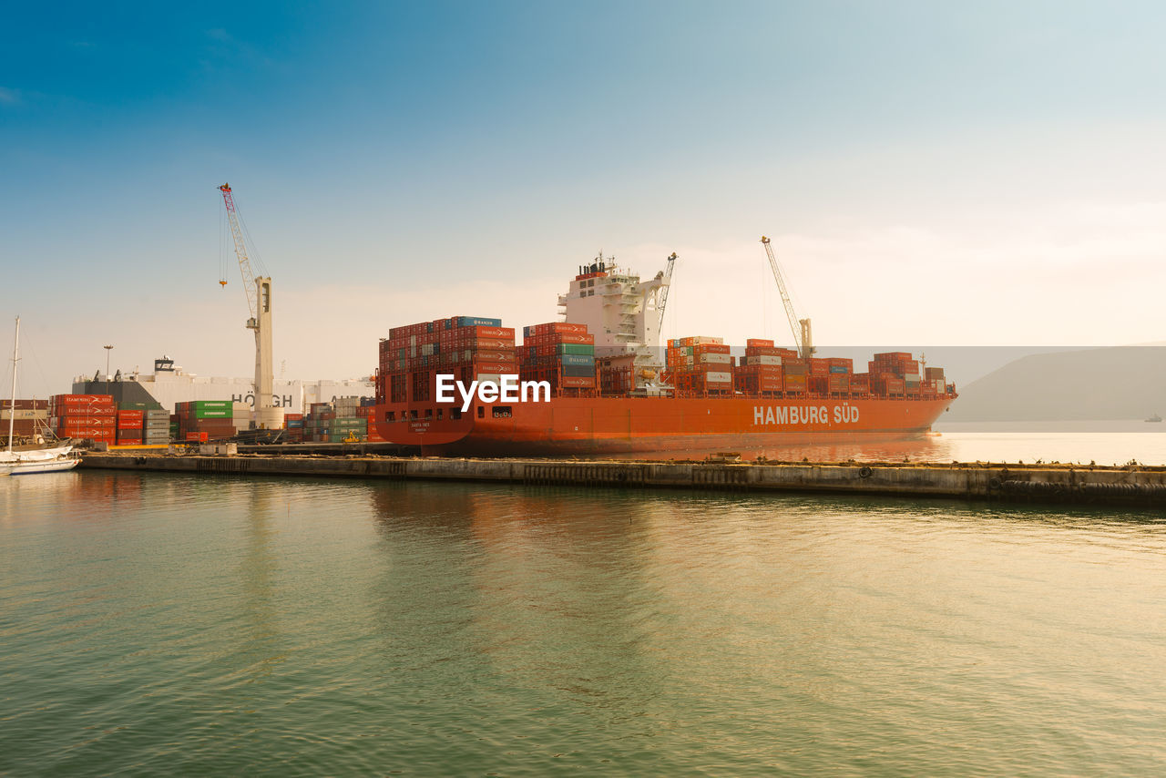 SHIP MOORED AT HARBOR AGAINST SKY