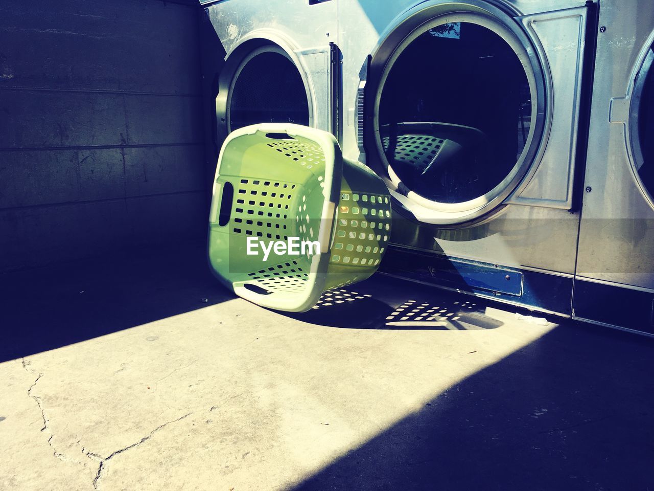 Laundry bucket by washing machine on floor